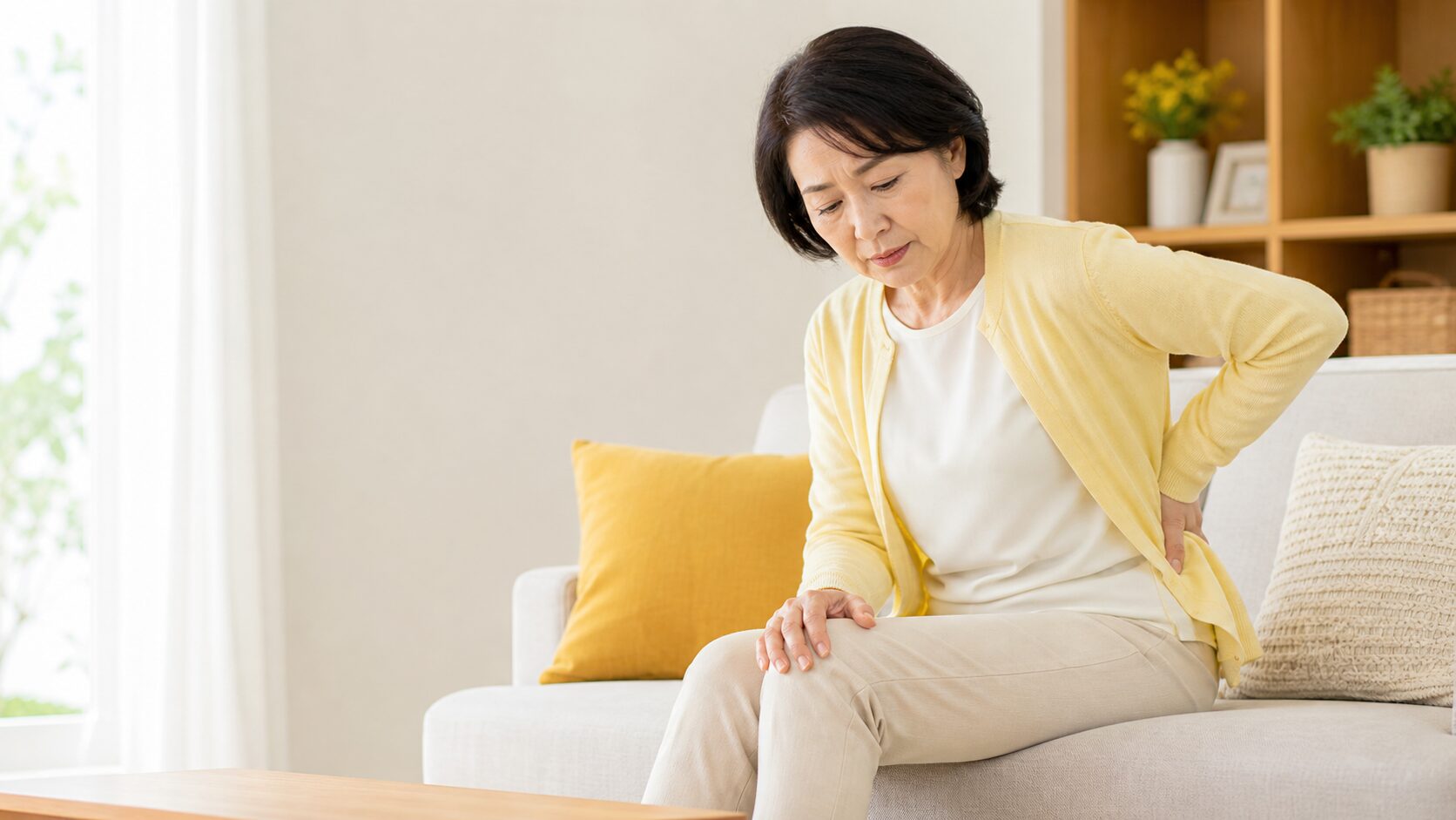 腰と膝に違和感を感じる50代女性のイメージ
